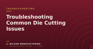 Wilson Manufacturing blog graphic titled 'Troubleshooting Common Die Cutting Issues' on a maroon background.